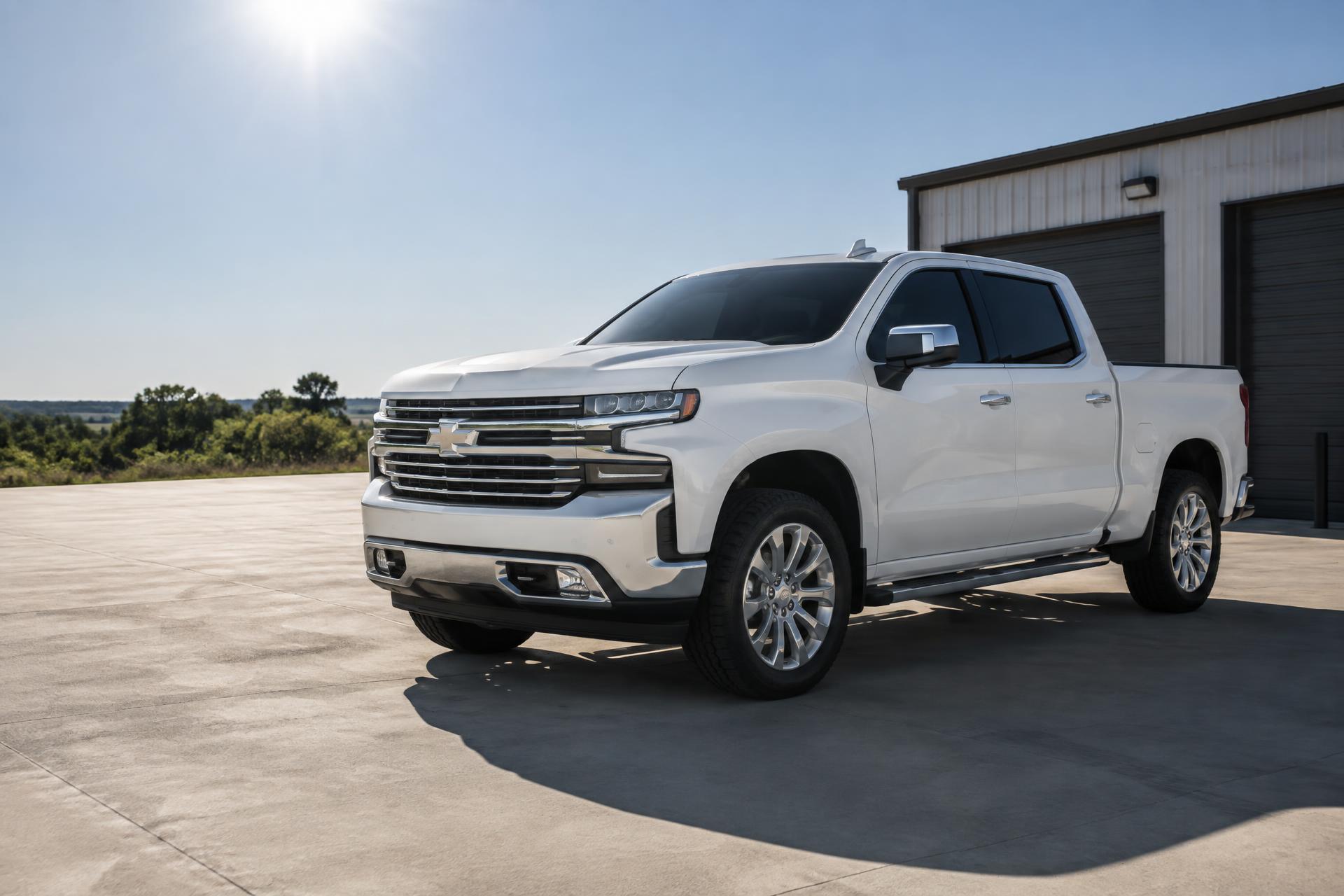 White pickup with ceramic window tint in bright Oklahoma sunlight outside a workshop